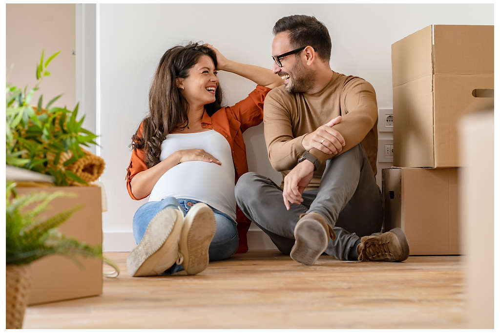 A couple smiling together while sitting on the floor