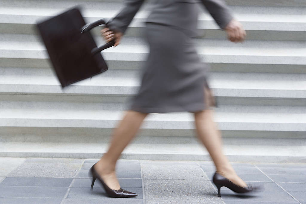 A working mother walking with a briefcase.