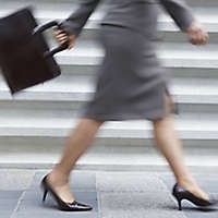 A working mother walking with a briefcase.