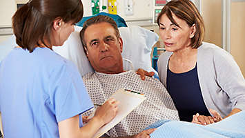 man in hospital with nurse and spouse
