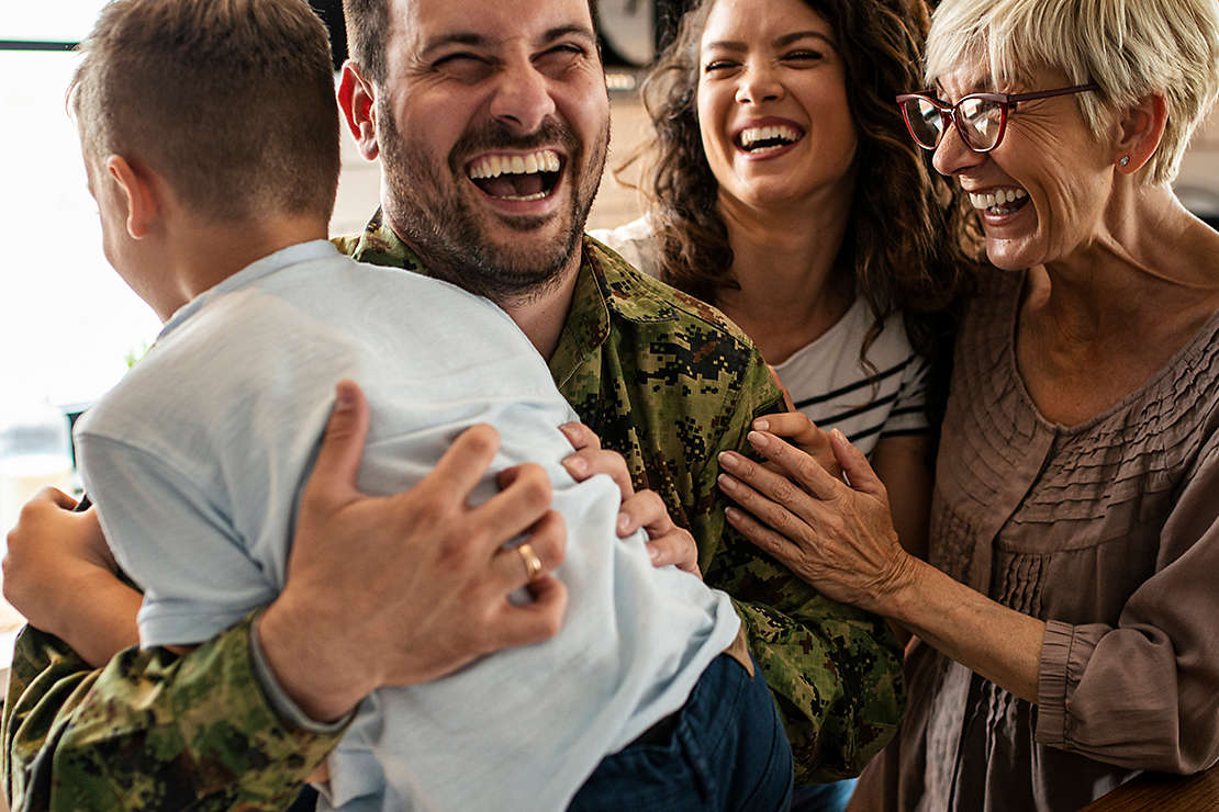 Family laughing together in their kitchen.