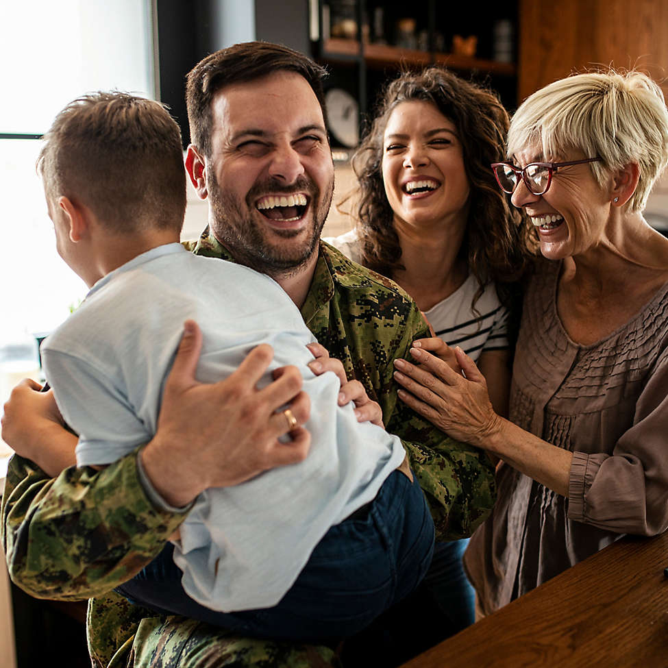 Family laughing together in their kitchen.