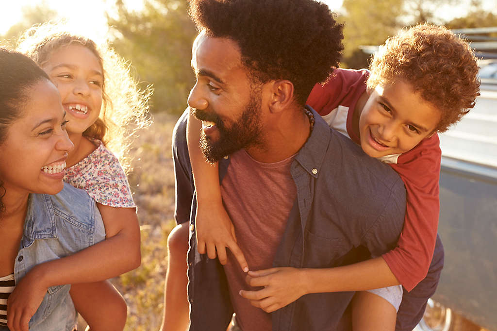 A family of four smiling together.