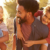 A family of four smiling together.