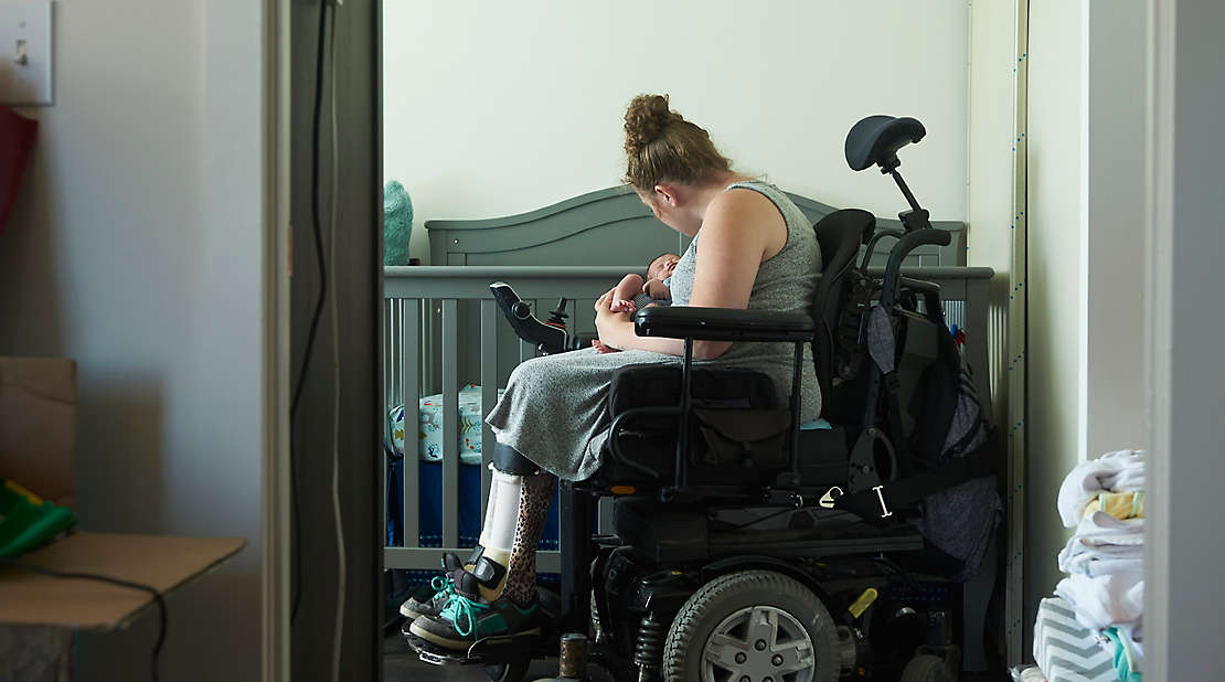  A person in a wheelchair holding their baby