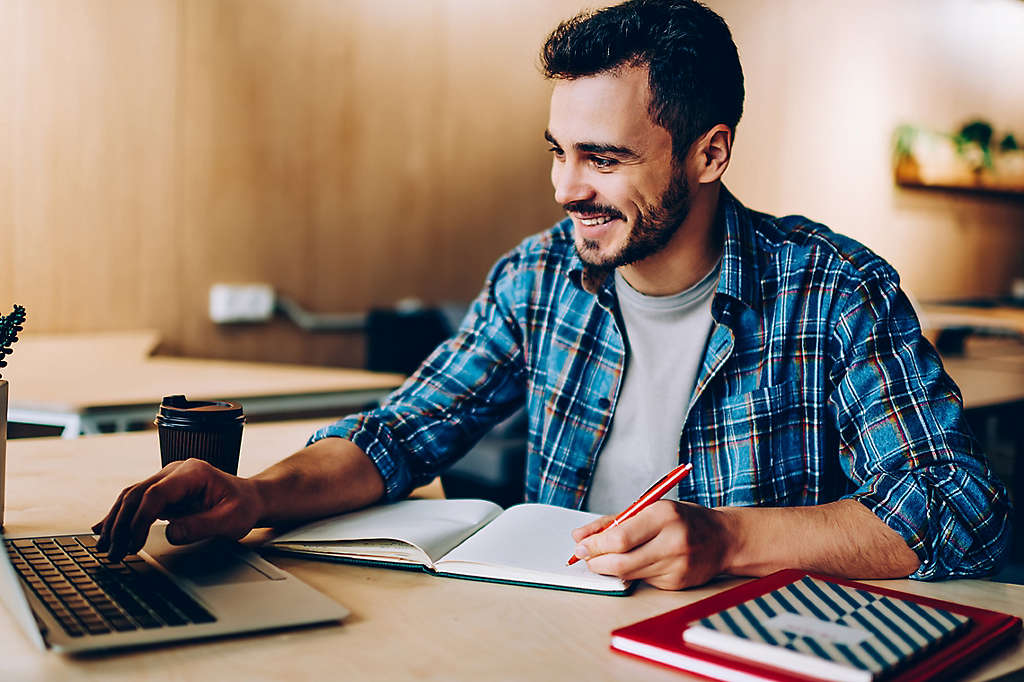 Man sitting at his desk smiling.