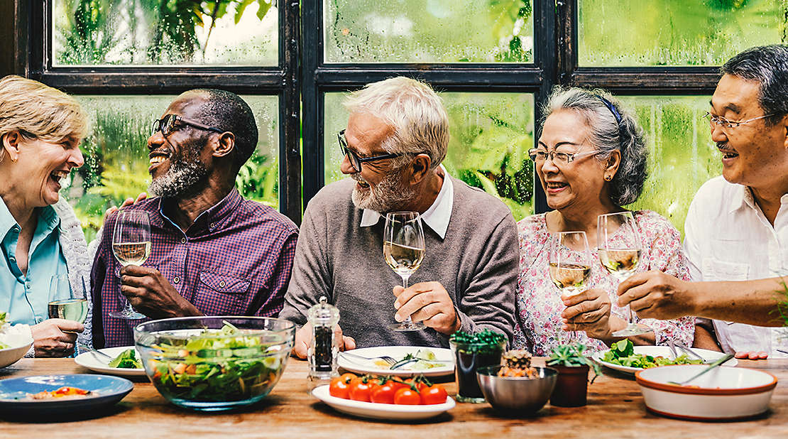 Five older friends toasting wine glasses.
