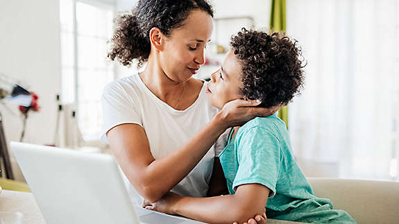 Mother and son together at a table.