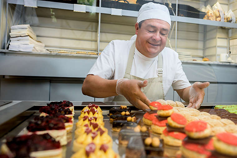 Baker working at the front counter of a bakery.