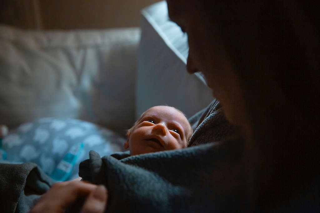 A mother tenderly holds her newborn baby at the hospital