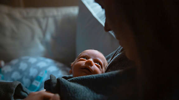 A mother tenderly holds her newborn baby at the hospital