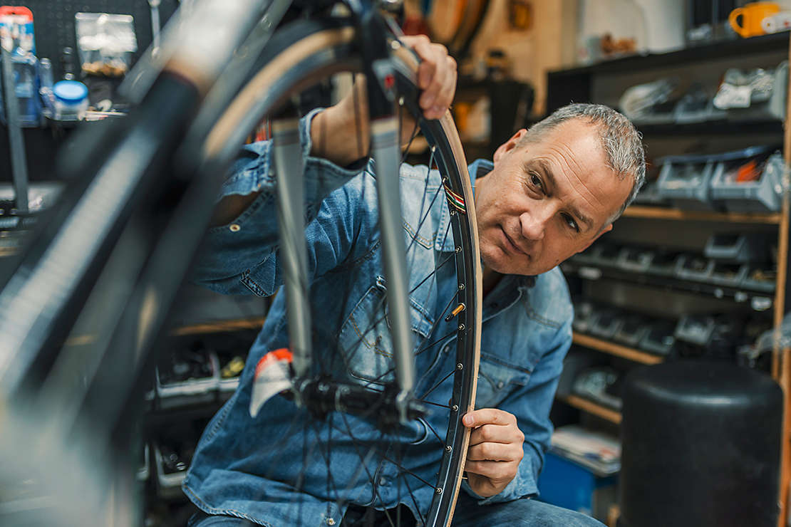 A man working on a bicycle in a repair shop