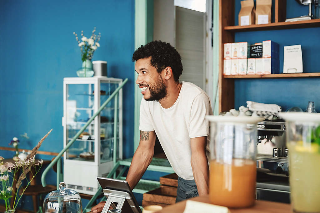 Barista smiling as he chats with customers in coffee shop