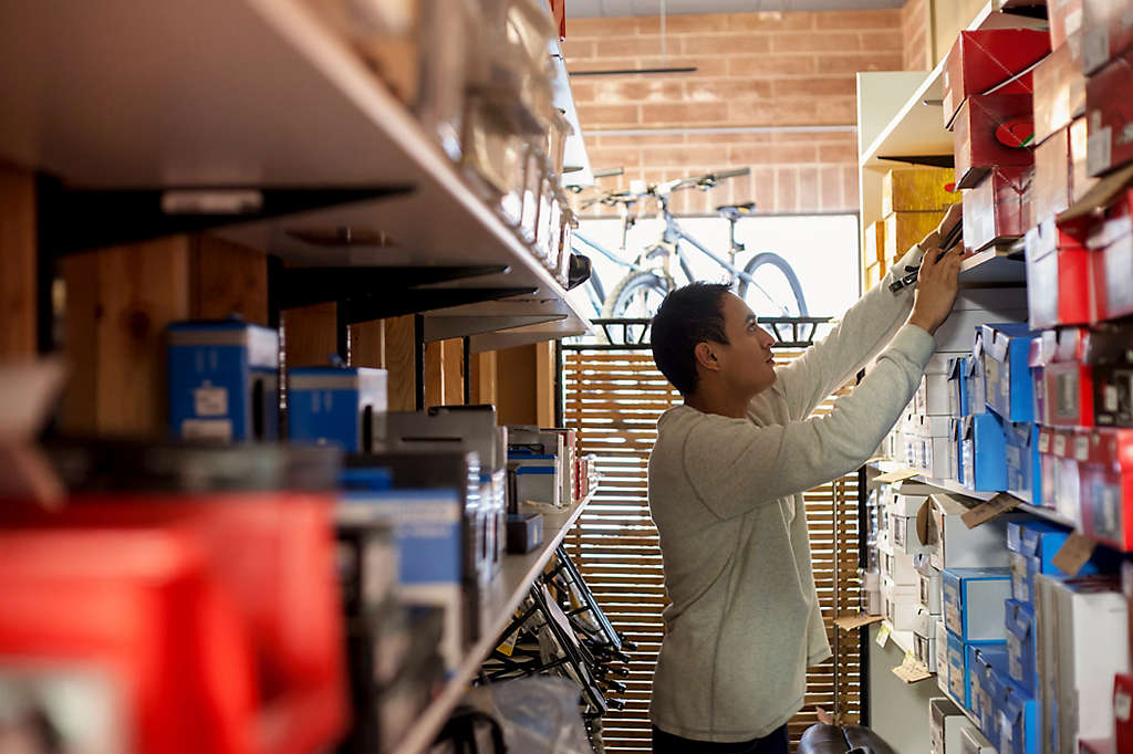 Salesman searching for box on store shelves