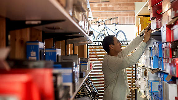 Salesman searching for box on store shelves