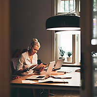 Woman working at table in kitchen