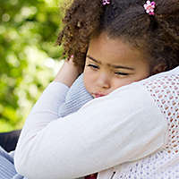 Small girl being hugged by her mom