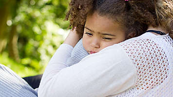 Small girl being hugged by her mom