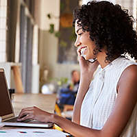 Woman sitting at a counter working on her laptop