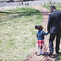 father and daughter leave the house holding hands