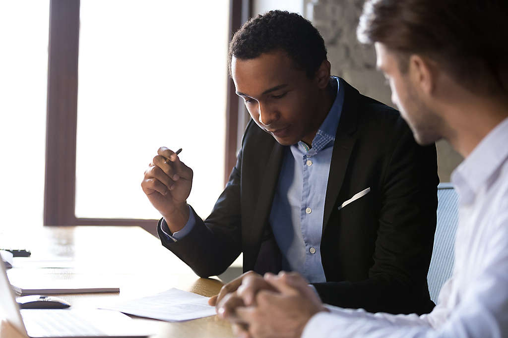 A young man looking over a document with an agent.