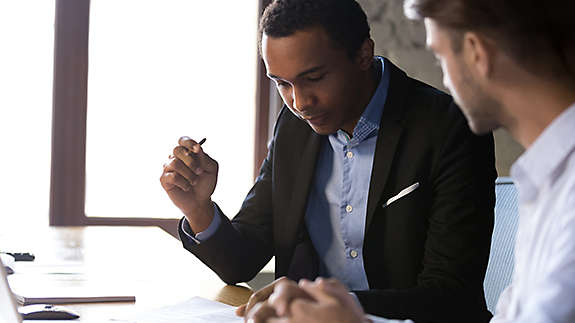 A young man looking over a document with an agent.