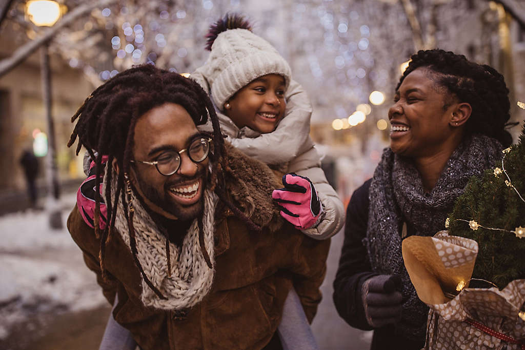 A young family walking outside talking and laughing.