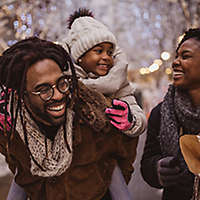 A young family walking outside talking and laughing.