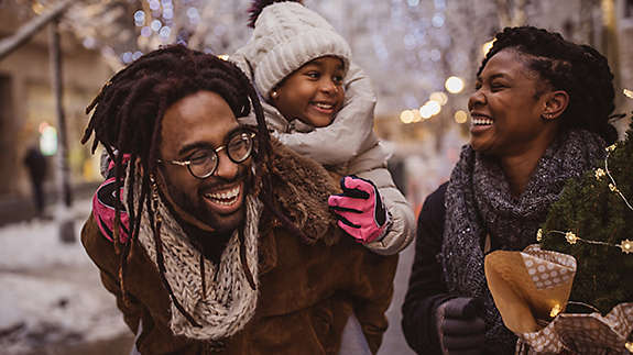 A young family walking outside talking and laughing.