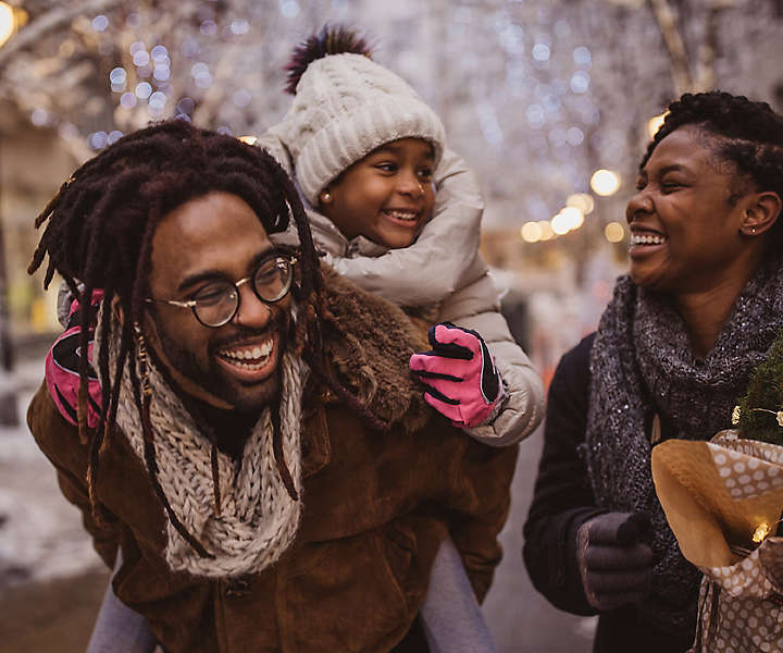 A young family walking outside talking and laughing.