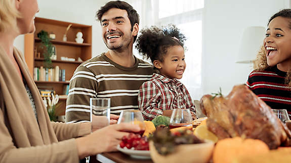 A family sitting around the dinner table laughing.