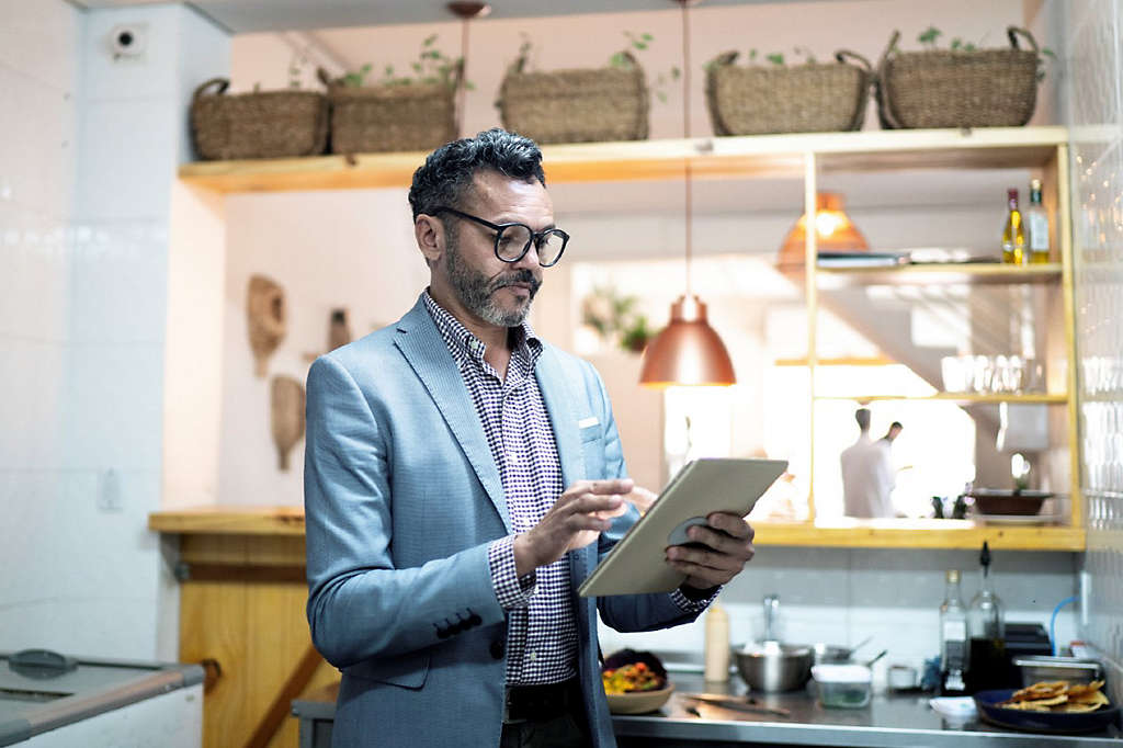 A person standing and working on a tablet