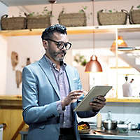 A person standing and working on a tablet