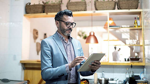 A person standing and working on a tablet