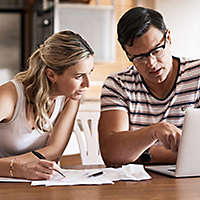 Couple looking at paperwork and a computer