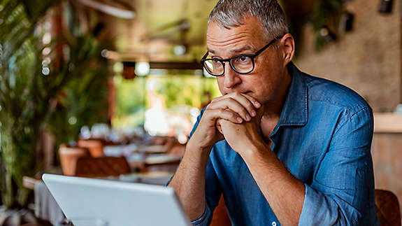 A man pondering something while sitting at his computer.