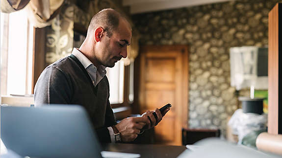 Businessman using a phone in home office