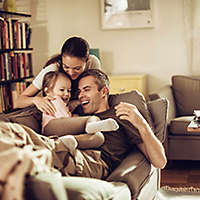 Family sitting on a couch together.