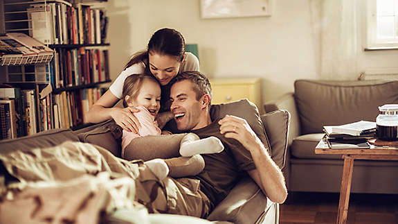 Family sitting on a couch together.