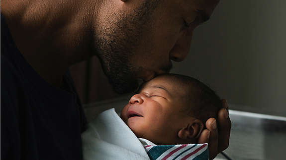 Young father holder his newborn baby.