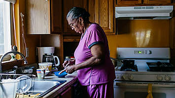Elderly women in kitchen cooking