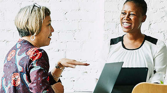 Two women sitting and laughing 