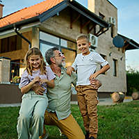 Grandfather with grandchildren and the house he intends to pass down to them
