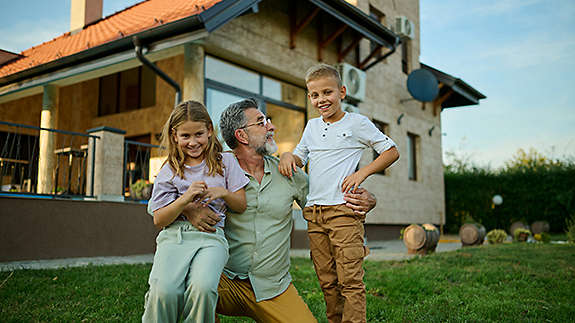 Grandfather with grandchildren and the house he intends to pass down to them