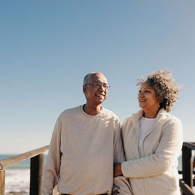 Mature couple taking a walk along a foot bridge at the beach