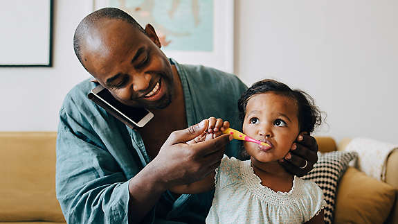Dad brushing daughters teeth
