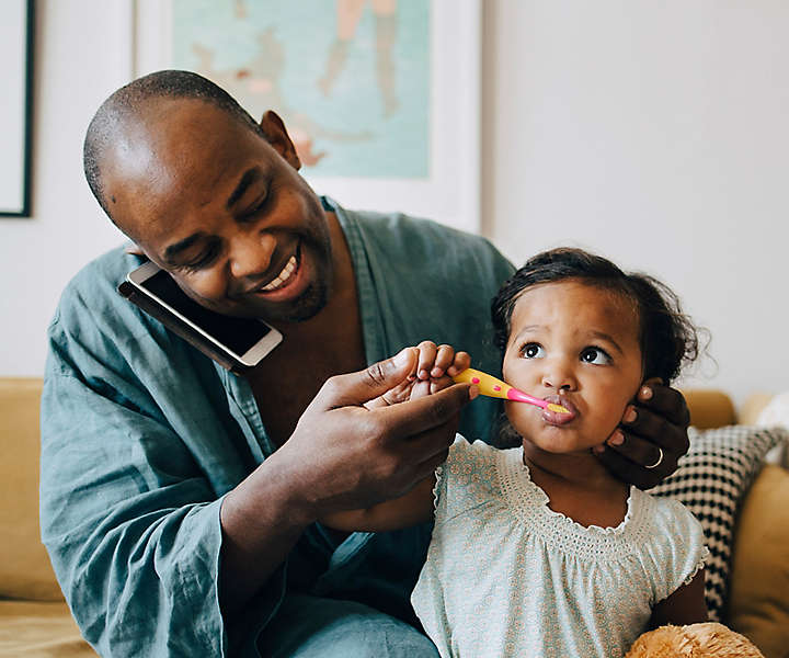 Dad brushing daughters teeth