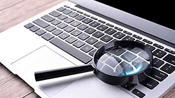 computer and magnifying glass