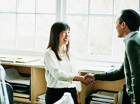 Employees in a meeting shaking hands