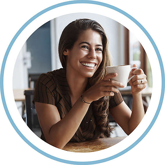 Person holding cup of coffee and smiling